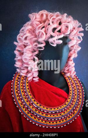 Manichino con capelli rosa, abiti a lettura profonda e collana con perline Maasai. Foto Stock