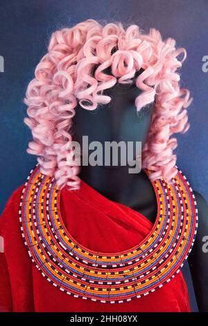 Manichino con capelli rosa, abiti a lettura profonda e collana con perline Maasai. Foto Stock
