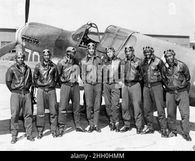 Un gruppo di Tuskeegee Airmen su un campo aereo di un Curtiss P-40 Tomahawk Foto Stock