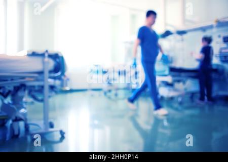 Personale medico che lavora nell'unità di terapia intensiva luminosa, background poco focalizzato. Foto Stock