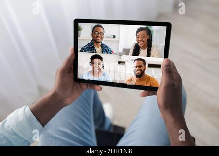 Uomo disabile irriconoscibile che ha chiamato con amici allegri, usando il pad Foto Stock