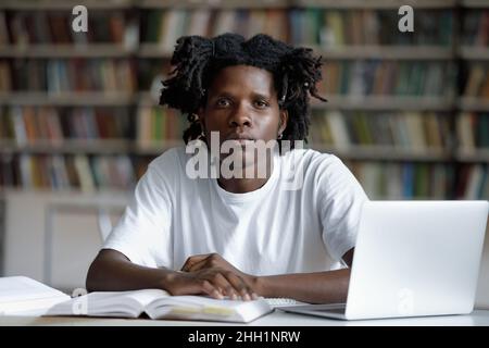 Studente universitario afroamericano serio con trendy teme Foto Stock