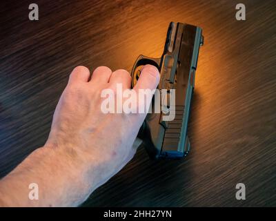 Vista dall'alto della pistola a mano su sfondo nero Foto Stock