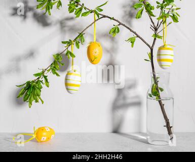 Composizione pasquale in vaso con rami d'albero e uova dipinte Foto Stock