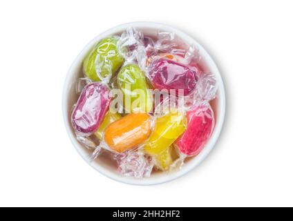 Frutta sherbets dolci caramelle in ceramica bianca ciotola su sfondo bianco. Vista dall'alto Foto Stock