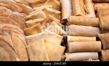 Un sacco di diverse frittelle in una vetrina in una panetteria, concetto di colazione background Foto Stock
