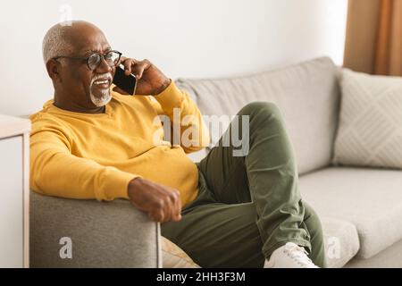 Senior African American Male parlare al telefono a casa, vista laterale Foto Stock