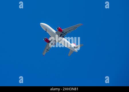 Aereo passeggeri. Vista esattamente dal basso, silhouette contro il cielo blu. Foto Stock