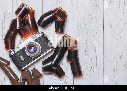 Vecchia macchina fotografica retrò con pellicole fotografiche su un tavolo di legno. Foto d'epoca Foto Stock