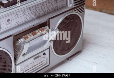 Una cassetta audio in un vecchio registratore a nastro retrò che si trova sul tavolo. Foto vecchio stile vintage filtrata Foto Stock