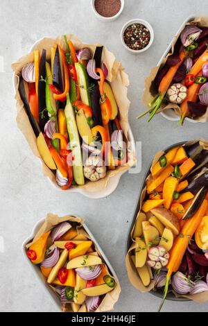 Verdure fresche tritate cucinate al forno in vari piatti di ceramica, vista dall'alto Foto Stock