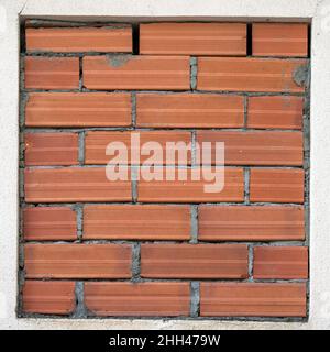 Primo piano di un telaio quadrato di finestra bloccato da mattoni cementati. Foto Stock