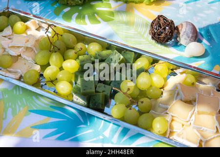 Il buffet alla reception. Assortimento di tartine su tavola di legno. Servizio banchetti. Ristorazione, spuntini con diversi tipi di formaggio. Concetto di partito. Foto Stock