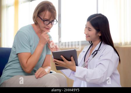 Medico donna e paziente anziano parlare e guardare sul computer tablet per la diagnostica e l'esame della malattia in ospedale, la diagnosi con il rapporto medico Foto Stock