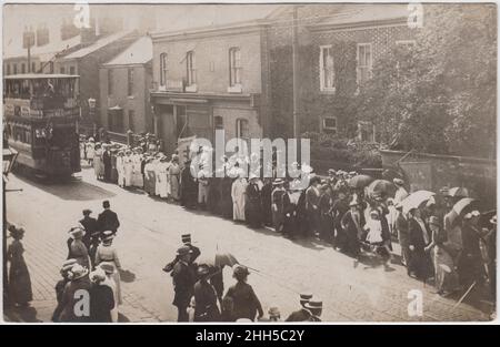 Parata della Chiesa: Linea di donne che sfilano attraverso una strada, guardata da una piccola folla. Portano diversi striscioni, tra cui uno per la St Mary's Guild. Un tram è a lato della processione e comprende un annuncio per John Williams & Sons, negozio alimentare. I locali di E. Lord & Son sono sullo sfondo, che può localizzarlo in George Street, Rochdale Foto Stock