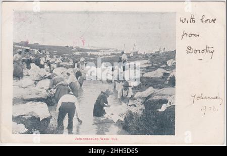 'Johannesburg wash tub': Uomini e donne che lavano vestiti / biancheria in un piccolo stagno o ruscello. Linee di vestiti sono appesi fino ad asciugare sullo sfondo. La cartolina fu inviata da Johannesburg a Rickmansworth, Inghilterra, nel 1903, poco dopo la fine della guerra dei boeri Foto Stock