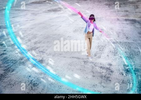 Ragazza adolescente che utilizza cuffie per realtà virtuale con le braccia allungate, facendo un cerchio luminoso sul sentiero Foto Stock