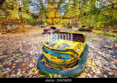 Ucraina, Kiev Oblast, Pripyat, abbandonate auto paraurti nel parco divertimenti Pripyat Foto Stock