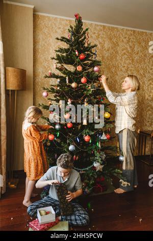 Famiglia decorazione albero di natale a casa Foto Stock