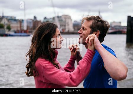 Coppia romantica che tiene le mani sul lungofiume Foto Stock