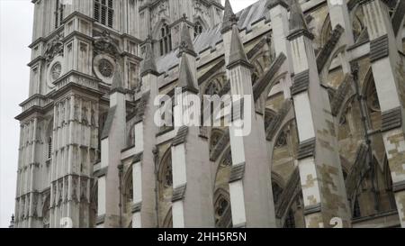 Vista dal basso sull'esterno dell'Abbazia di Westminster contro il cielo nuvoloso grigio. Si tratta di una grande chiesa abbaziale principalmente gotica nella Città del W. Foto Stock