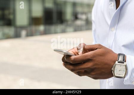 Giovane che fa SMS sullo smartphone Foto Stock