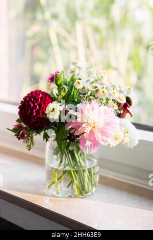 Vaso con fiori colorati in piedi sul davanzale Foto Stock