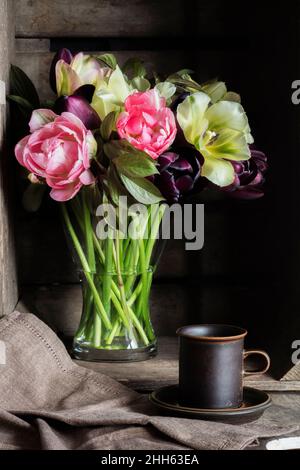 Shot studio di tazza di caffè e bouquet di tulipani Pink Star, Spring Green e Queen of Night Foto Stock