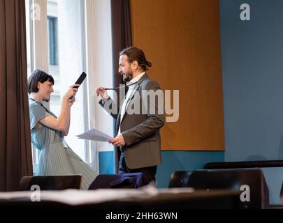 Donna d'affari che scansiona la carta d'identità di un collega tramite un tablet PC Foto Stock