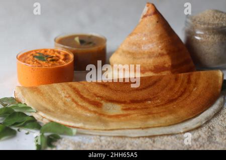 Crepes croccante fatto di piccoli milletti e lenticchie. Comunemente noto come piccola dose di miglio. Placcati in forma conica e in rotoli. Servito con cocco speziato c Foto Stock