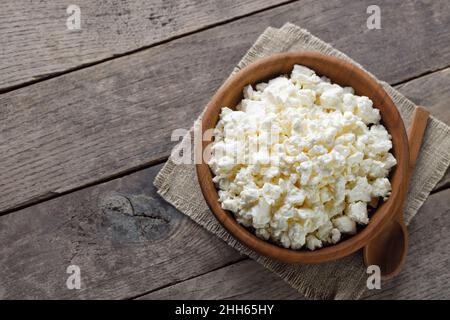 vista dall'alto del formaggio casolare in una ciotola di legno marrone con cucchiaio Foto Stock