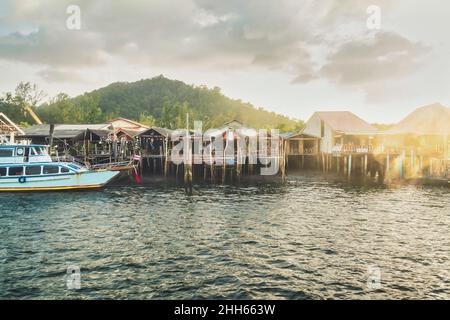 Palafitte case di fronte alla montagna al tramonto, Ko Lanta, Thailandia Foto Stock