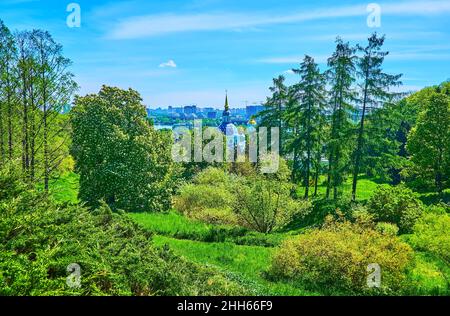 Il dolce pendio verde della collina è coperto da diverse piante dell'Orto Botanico di Kyiv la cupola stellare del Monastero di Vydubychi è visibile nella ba Foto Stock