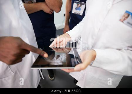 Gli operatori sanitari discutono di PC tablet in ospedale Foto Stock