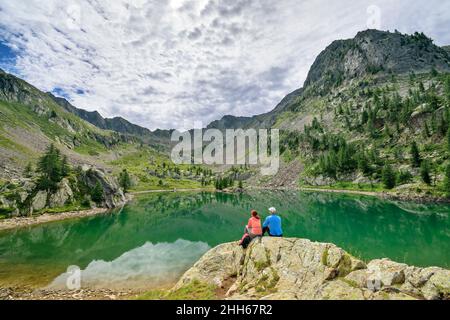 I turisti che guardano al Lago de Trecolpas Parco Nazionale del Mercantour, Francia Foto Stock