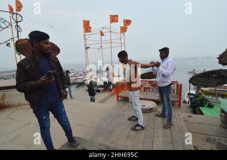 Varanasi, India. 22nd Jan 2022. Uomini che fanno yoga durante la pandemia di Covid-19 dal fiume Ganga, a Varanasi, Uttar Pradesh, India, il 22 gennaio, 2022. (Foto di Ravi Batra/Sipa USA) Credit: Sipa USA/Alamy Live News Foto Stock