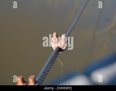 Un filo spesso e resistente con viti tiene in posizione un ponte. Foto Stock