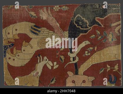 Frammento di un animale Carpet fine 16th secolo il tema degli animali fantastici e grotteschi è stato popolare durante l'ultimo quarto del sedicesimo secolo in India di Mughal. Questo frammento di tappeto di pelo di lana su trama e ordito di cotone è uno dei tipi più rari di tappeti Mughal. Una capra sporge dalla bocca di un leone mentre gli uccelli sovrapposti si affacciano reciprocamente su uno sfondo rosso tipico dei tappeti Mughal. Lo schema complessivo è enigmatico con fogliame sparso tra le creature. Sembra che sia stato ispirato dalla makara-torana indiana un arco in cui scorre problema da Foto Stock