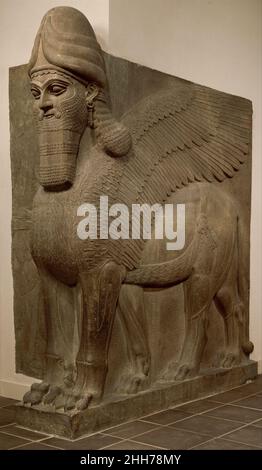 Leone alato a testa umana (lamassu) ca. 883–859 a.C. assiro dal IX al VII secolo a.C., i re d'Assiria dominarono un vasto impero centrato nel nord dell'Iraq. Il grande re assiro Ashurnasirpal II (r. 883–859 a.C.), ha intrapreso un vasto programma di costruzione a Nimrud, antica Kalhu. Fino a quando divenne la capitale sotto Ashurnasirpal, Nimrud era stato non più di una città provinciale.la nuova capitale occupava un'area di circa nove cento acri, intorno al quale Ashurnasirpal costruì un muro di mattoni di fango che era spesso 120 piedi, alto 42 piedi e lungo cinque miglia. Nell'angolo sud-ovest Foto Stock