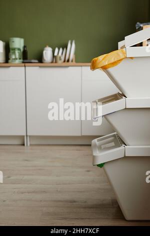 Vista laterale verticale di tre contenitori di smistamento rifiuti impilati in cucina, spazio copia Foto Stock