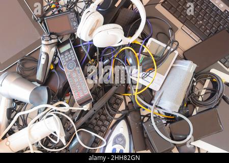 Vista dall'alto su vecchi computer, tablet digitali, telefoni cellulari, molti dispositivi elettronici usati, elettrodomestici e elettrodomestici rotti. Obsolescenza pianificata Foto Stock