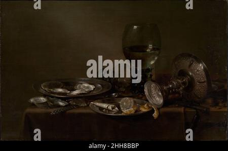 Still Life with Oysters, a Silver Tazza, and Glassware 1635 Willem Claesz Heda Dutch Un tavolo con ostriche, un limone e birra invita lo spettatore ad associare il piacere visivo e culinario. Ma uno sguardo più da vicino rivela il vetro rotto e un cono di carta (destinato a contenere le spezie) strappato da un almanacco, entrambi ricordi dei nostri giorni che passano rapidamente. Heda si è fatto un nome per sé come artista ottenendo una varietà di effetti pittorici, come l'illusione di argento lucido, ostriche scintillanti, o vetro riflettente, mentre lavorando quasi esclusivamente in tonalità di grigio. Ascoltate gli esperti che illuminano questo ar Foto Stock