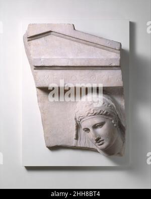Frammento di una stele marmorea di una donna ca. 400–390 a.C. Greco, Attico inscritto sull'architrave 'la figlia di [ ] omenes' le caratteristiche regolari e i piani semplificati di questo volto impartiscono una quiete dignità e serenità che sono segni distintivi dell'alta arte classica. Frammento di stele di una tomba di marmo di una donna 253047 greco, Attico, frammento di stele di una tomba di marmo di una donna, ca. 400?390 a.C., marmo, Pentelico, H. 26 7/8 poll. (68,2 cm). Il Metropolitan Museum of Art, New York. Fletcher Fund, 1930 (30.11.3) Foto Stock