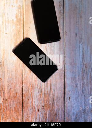 due telefoni cellulari in legno rustico chiaro Foto Stock