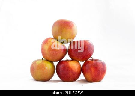 Pila di mele organiche a forma di piramide isolata su sfondo bianco. Foto Stock