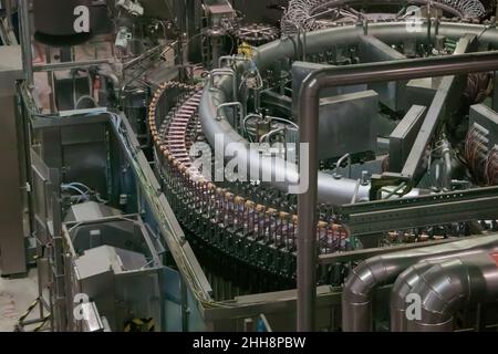 Linea di produzione della birra - nastro trasportatore con bottiglie in plastica Foto Stock