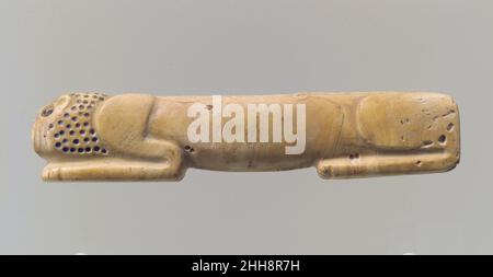 Amuleto sotto forma di leone cimino ca. 2900–2700 a.C. questo piccolo oggetto scolpito da un pezzo di conchiglia raffigura un leone reclinato con la testa poggiata sulle zampe anteriori. Gli elementi del corpo dell’animale sono semplicemente modellati: Fiocchi, corpo, spalle e zampe anteriori, e testa possono essere identificati. La schiena è dritta e la pancia pende leggermente verso il basso. I piccoli fori trapanati segnano il mane e i fori più grandi indicano l'occhio e l'orecchio. Tracce di pigmento in questi fori suggeriscono che sono stati inizialmente intarsiati con un materiale in un colore contrastante. I Lions erano uno degli animali più rappresentati Foto Stock