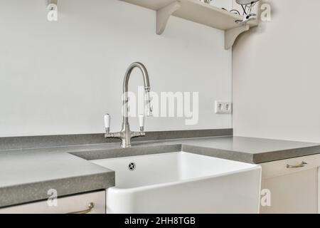 Lussuoso bagno con specchio e bottiglie di profumo accanto a un vaso di  fiori accanto al rubinetto di argento e bianco con dissipatore di  asciugamani Foto stock - Alamy