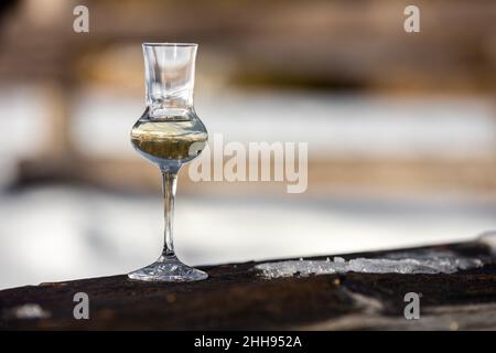 Bokeh foto di un bicchiere di Grappa aromatizzata (schnapps) a Cortina d'Ampezzo, Dolomiti, Italia Foto Stock