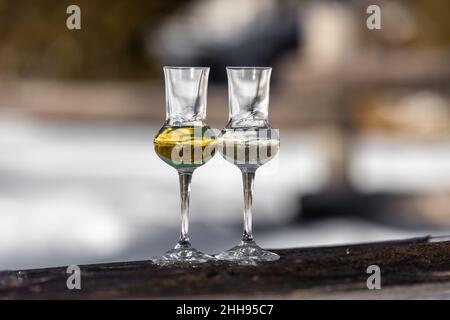 Bokeh foto di due bicchieri di Grappa aromatizzata (schnapps) a Cortina d'Ampezzo, Dolomiti, Italia Foto Stock